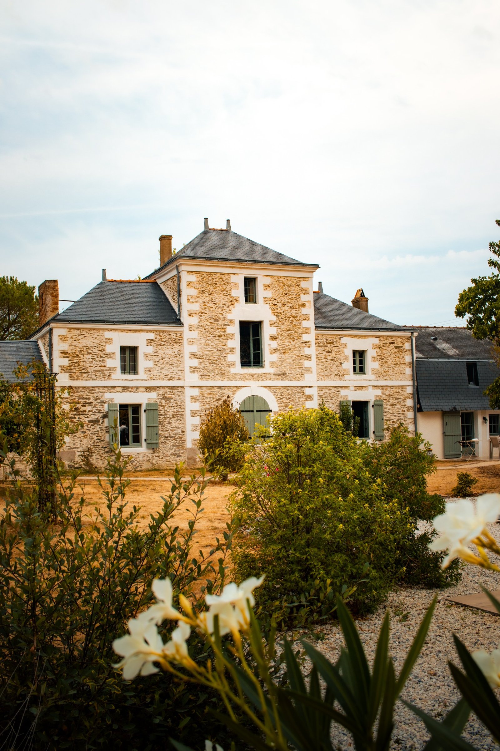 Balcon en pierre claire d'une bâtisse française, avec mobilier de jardin en fer forgé