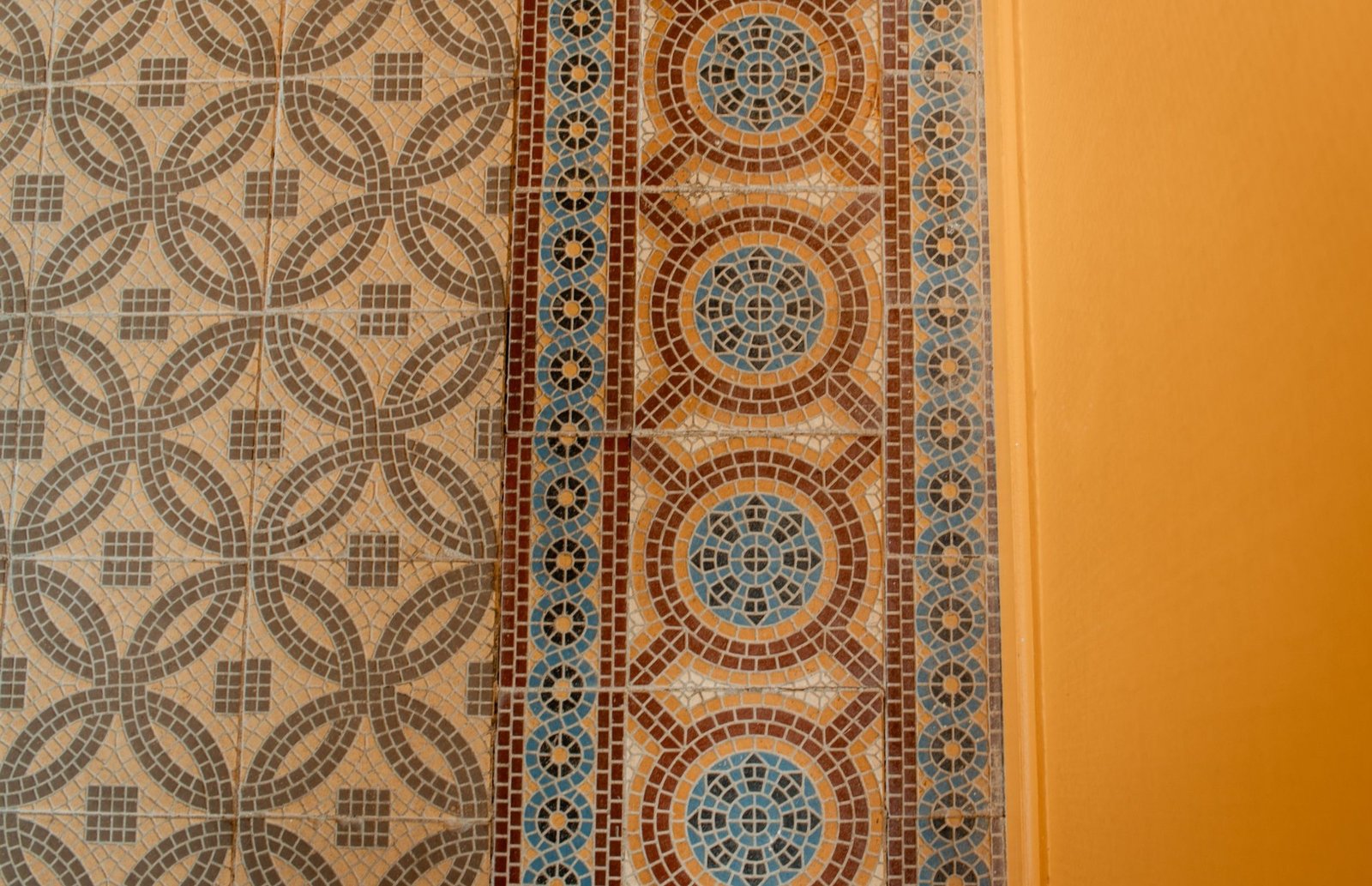 Détail d'une mosaïque ancienne aux tons crème, brun et bleu